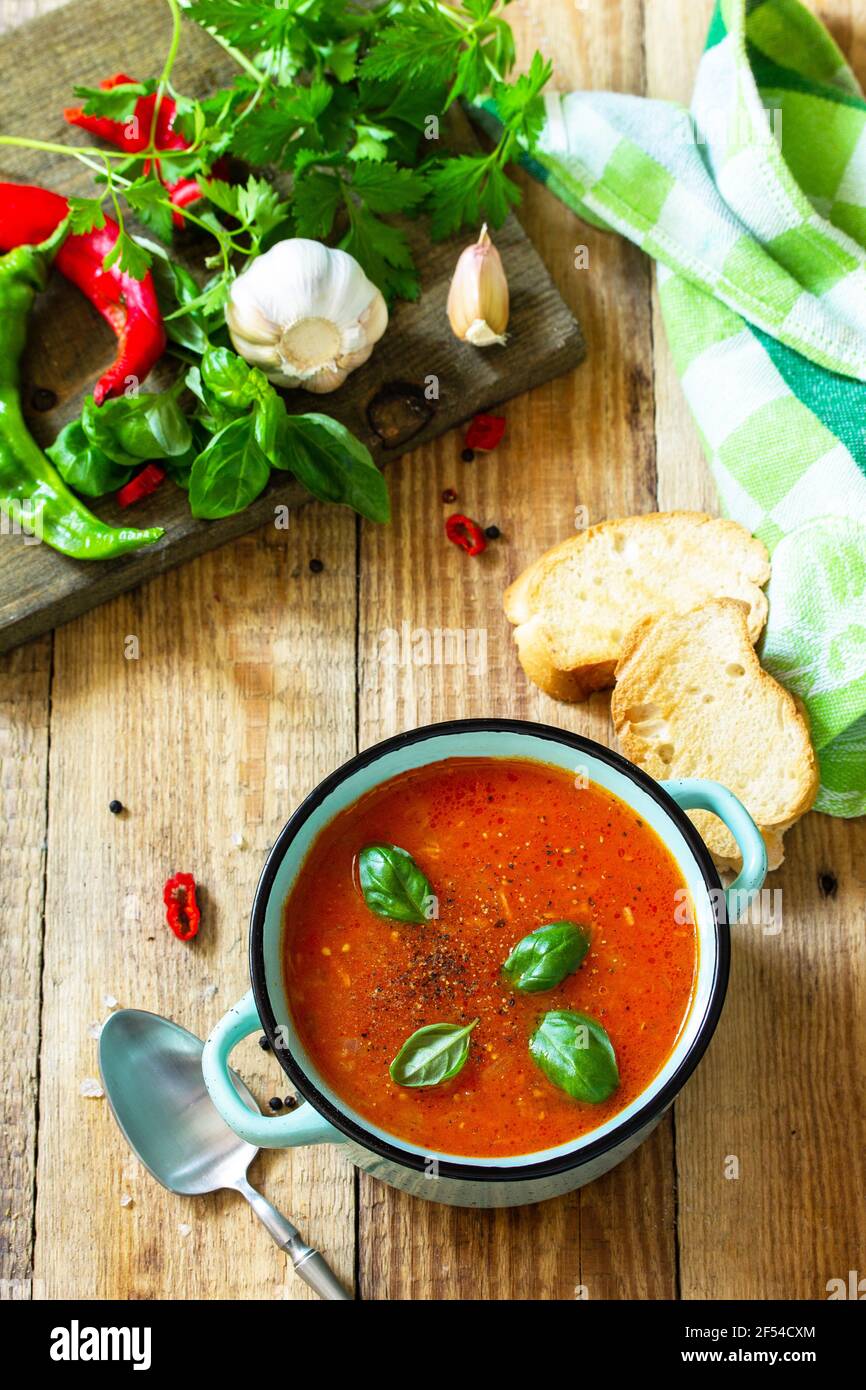 Il concetto di cibo sano e dietetico, piatto vegetariano. Zuppa di pomodoro o zuppa di gazpacho con crostini su un tavolo rustico in legno. Foto Stock