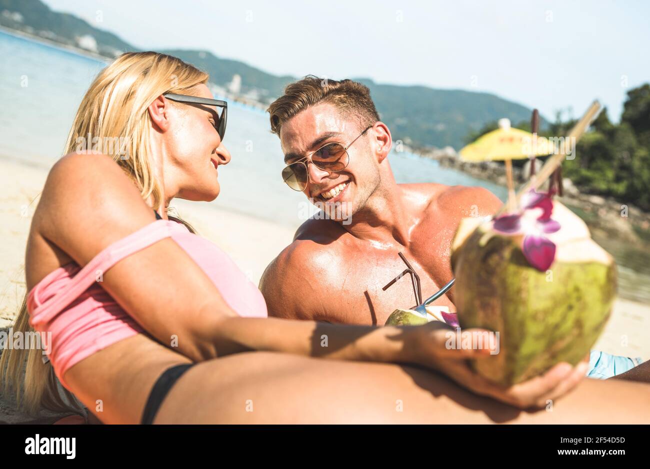 Ritratto di giovane coppia vacanziere divertirsi sulla tropicale Phuket spiaggia in Thailandia con bevanda al cocco - giovani attivi e. concetto di viaggio Foto Stock