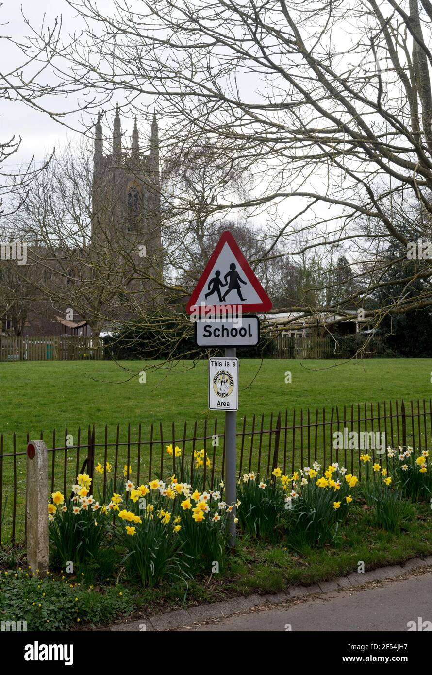 Un cartello scolastico e la chiesa di San Pietro`s in primavera, Hampton Lucy, Warwickshire, Inghilterra, UK Foto Stock