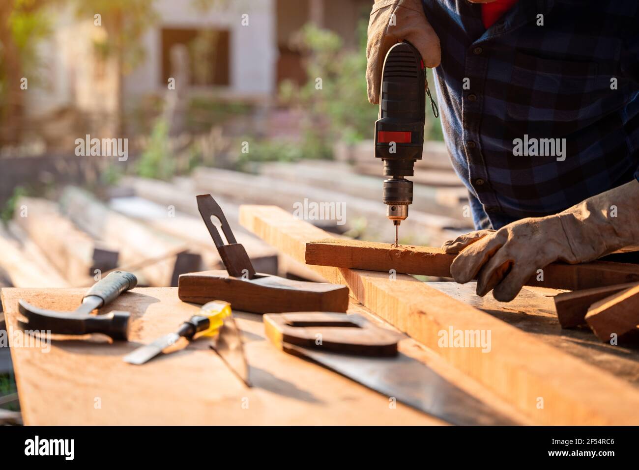 Primo piano mano di Carpenter perfora un foro con un trapano elettrico. Foto Stock