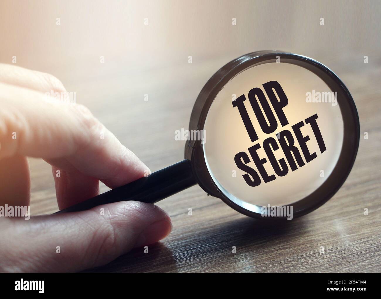 lente di ingrandimento sul testo segreto superiore. Concetto di business e istruzione Foto Stock