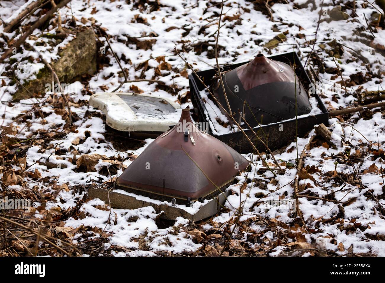 I vecchi tubi catodici scartati in una discarica illegale di rifiuti forestali. Rifiuti elettronici nella foresta. Foto scattata in condizioni di scarsa illuminazione. Foto Stock