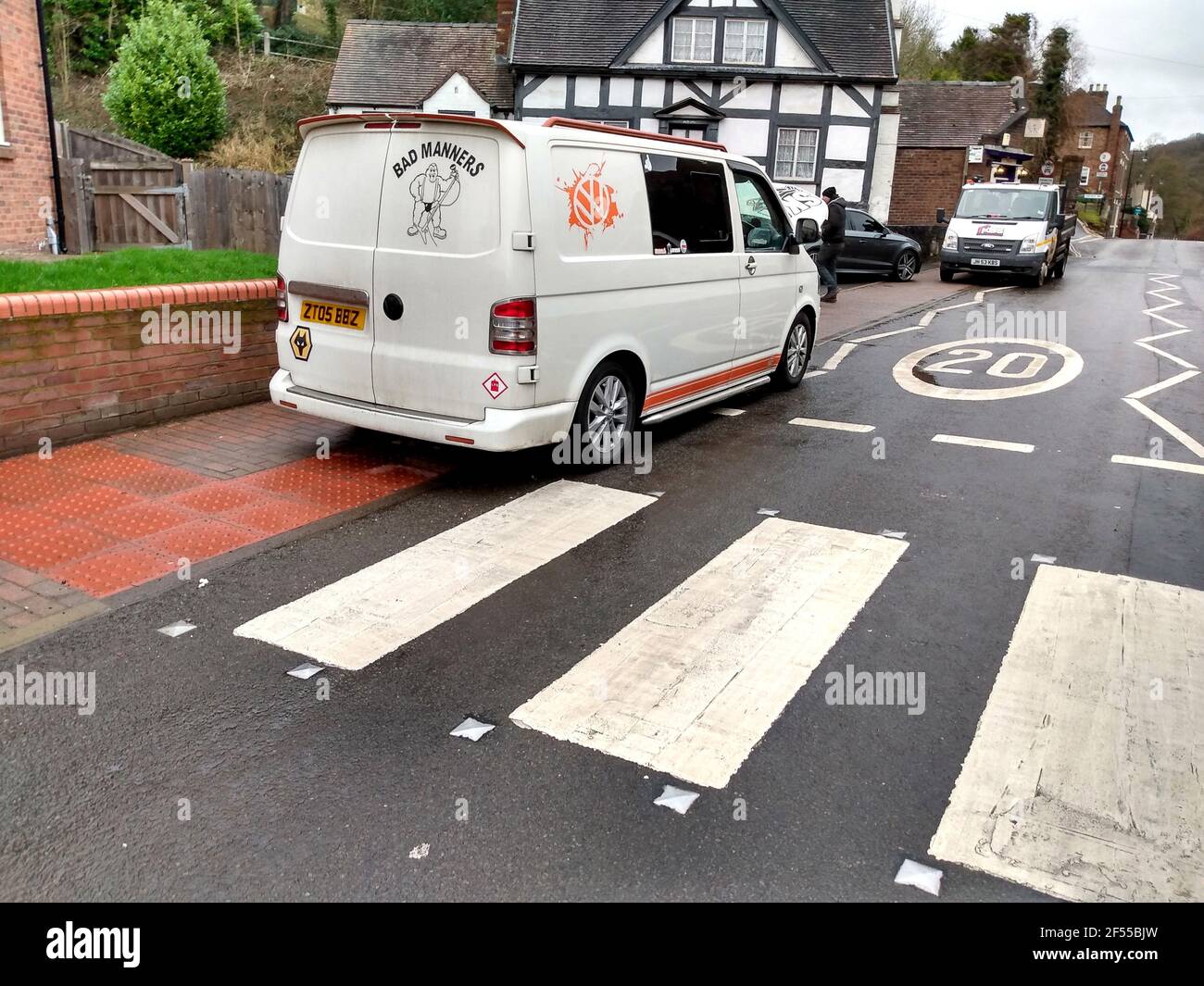 Cattive maniere! Furgone bianco con logo 'Bad Manners' parcheggiato sulla zebra pedonale che attraversa la Gran Bretagna, Regno Unito Foto Stock