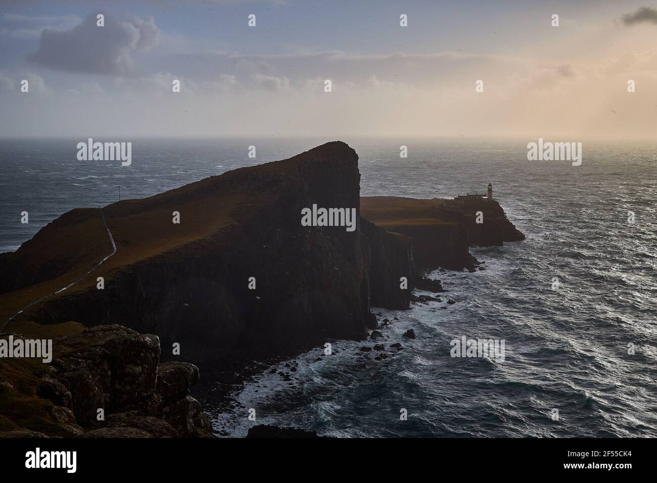 Tramonto al faro di Neist Point - Isola di Skye (Glendale, Scozia). Lunga scogliera con un faro sullo sfondo. Foto Stock