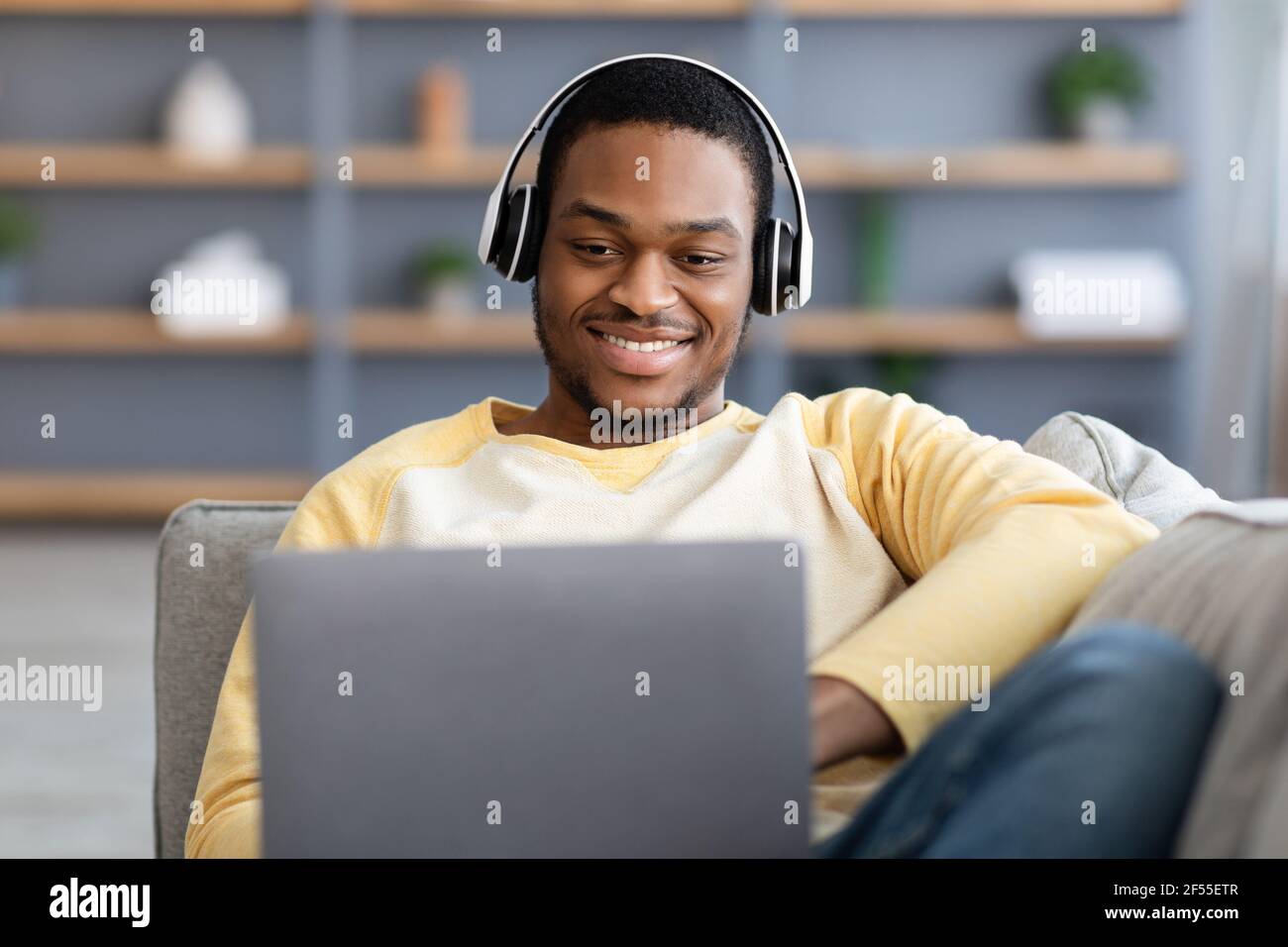Primo piano di un ragazzo nero felice che gioca a videogiochi su un computer portatile Foto Stock