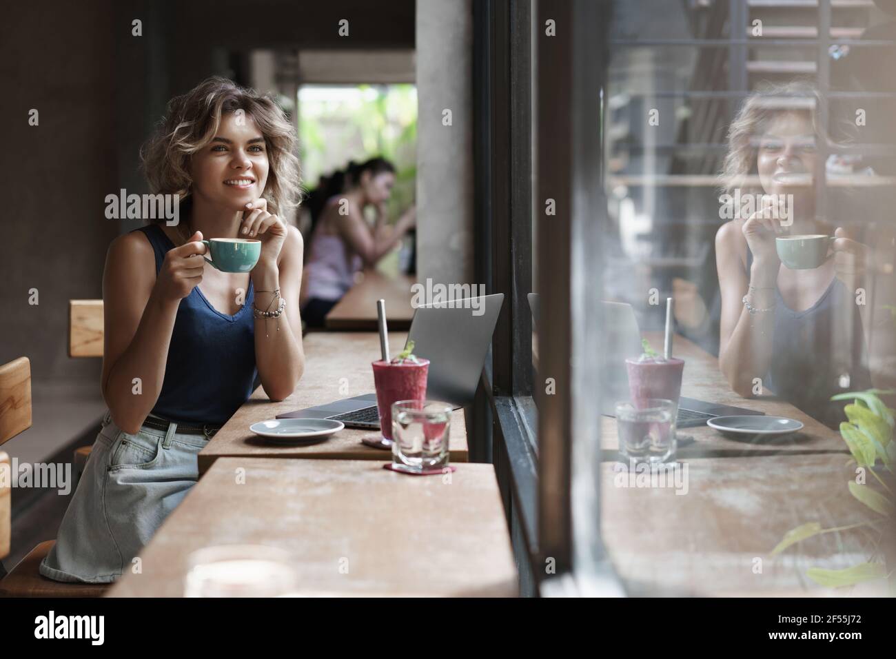 Dreamy felice fortunato giovane seducente ragazza seduta caffè tavolo caffè cappuccino bevanda, frullato guardando attraverso i passersby finestra premuroso creazione Foto Stock