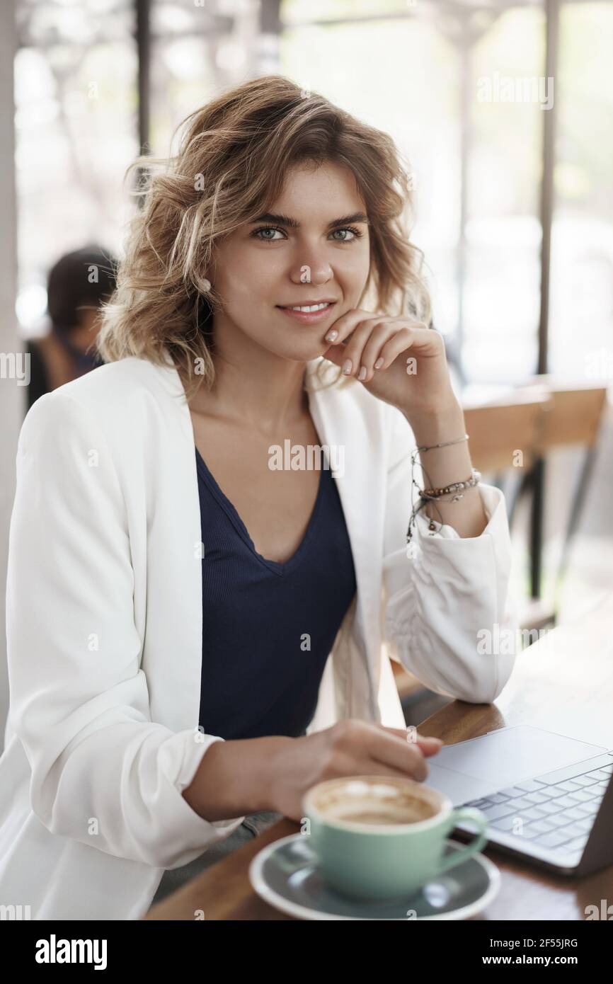 Vertical shot sicuro successo biondo capelli ricci giovane imprenditore freelance femminile i manager dei social media lavorano al di fuori del concetto di economia aziendale Foto Stock