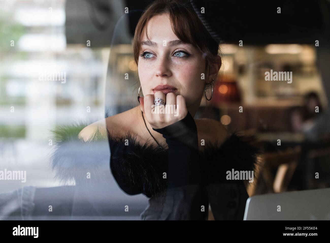 Bella donna d'affari con gli occhi blu guardando attraverso la finestra al caffè Foto Stock