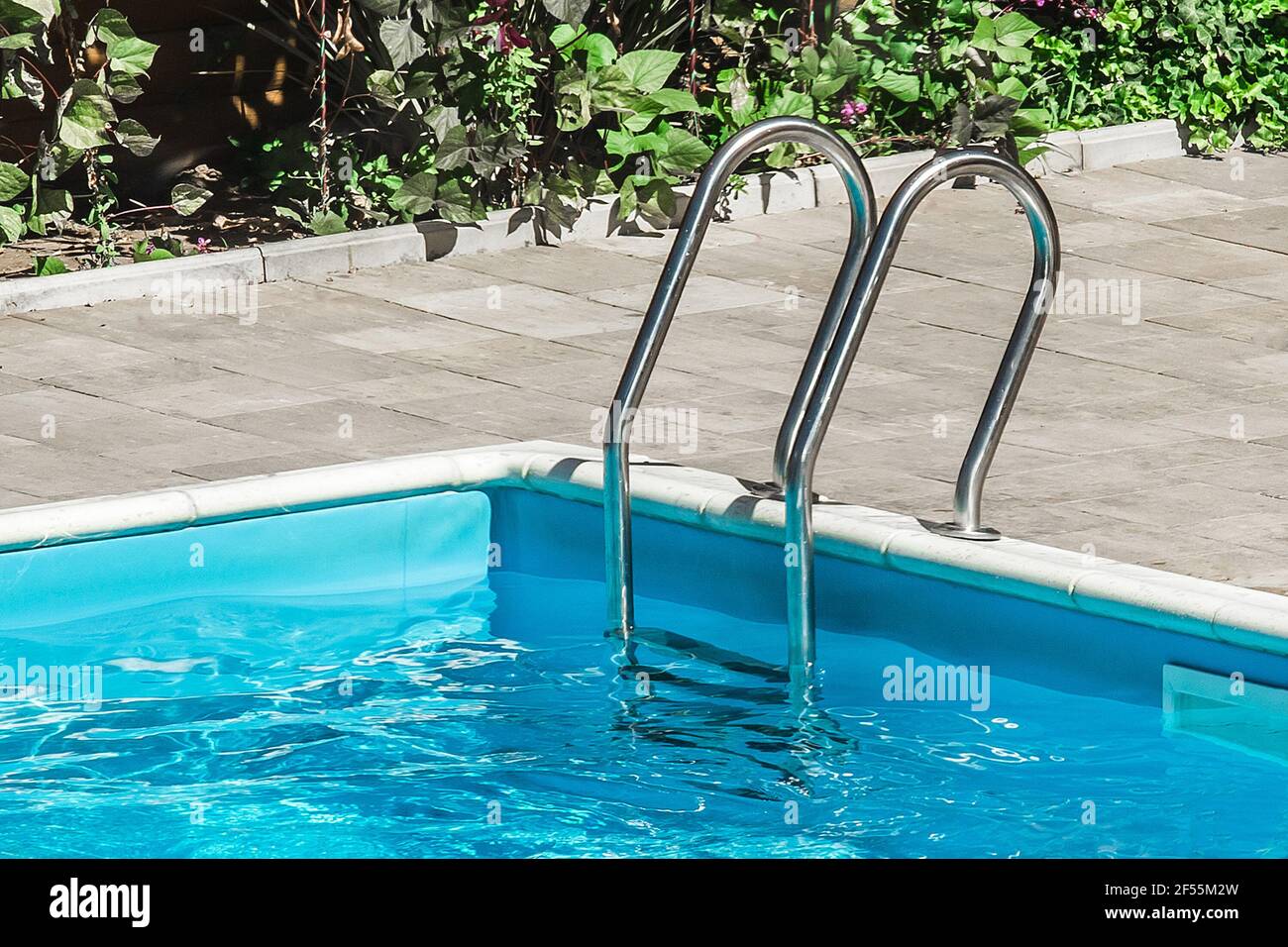 Corrimano di sicurezza vicino alla piscina, acqua blu all'aperto, primo piano. Foto Stock