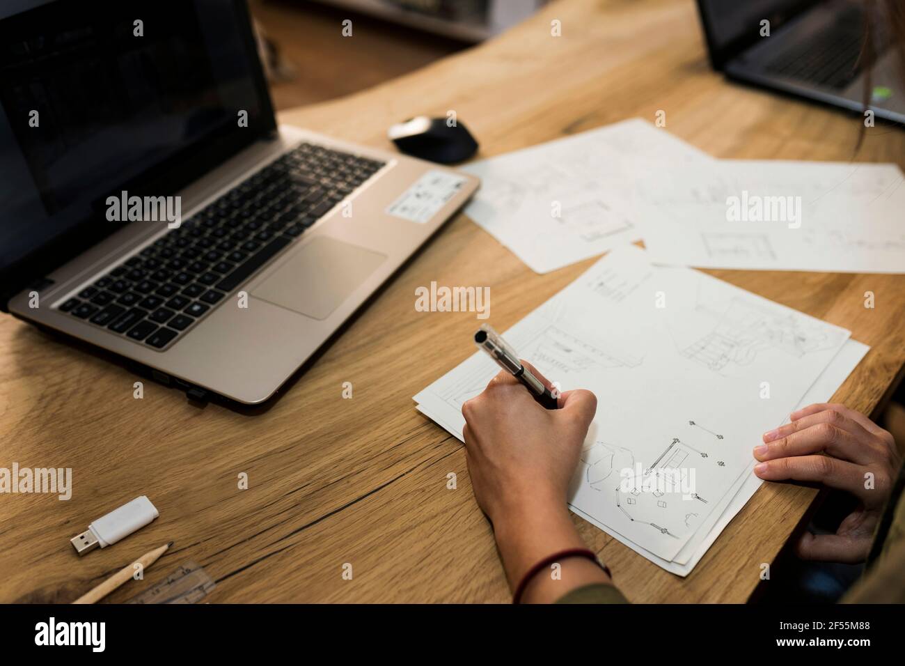 Carpentiere femmina che fa il disegno sulla carta alla scrivania nell'industria Foto Stock