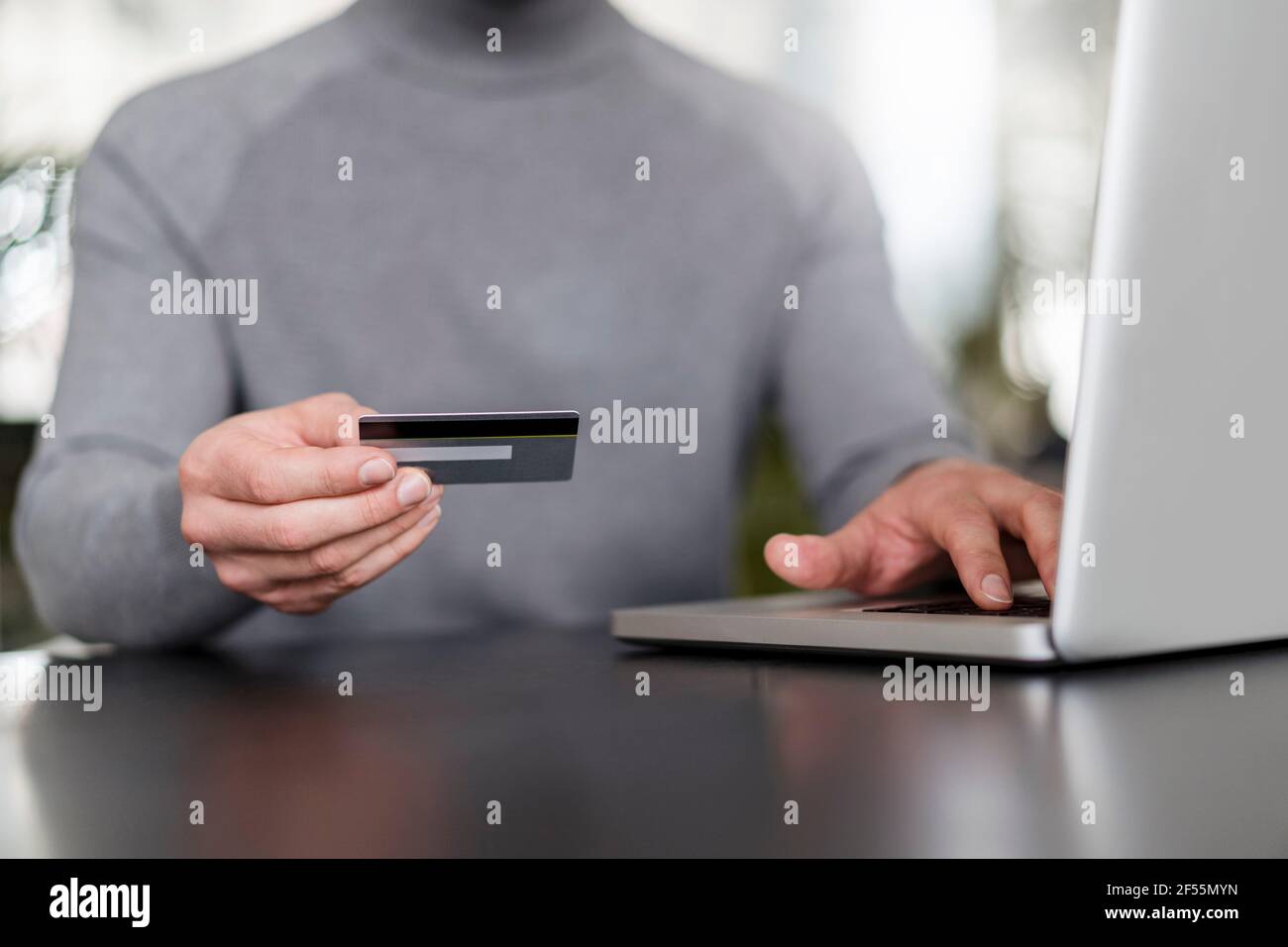 Mani di uomo d'affari in linea che pagano con la carta di credito sul laptop a. ufficio Foto Stock