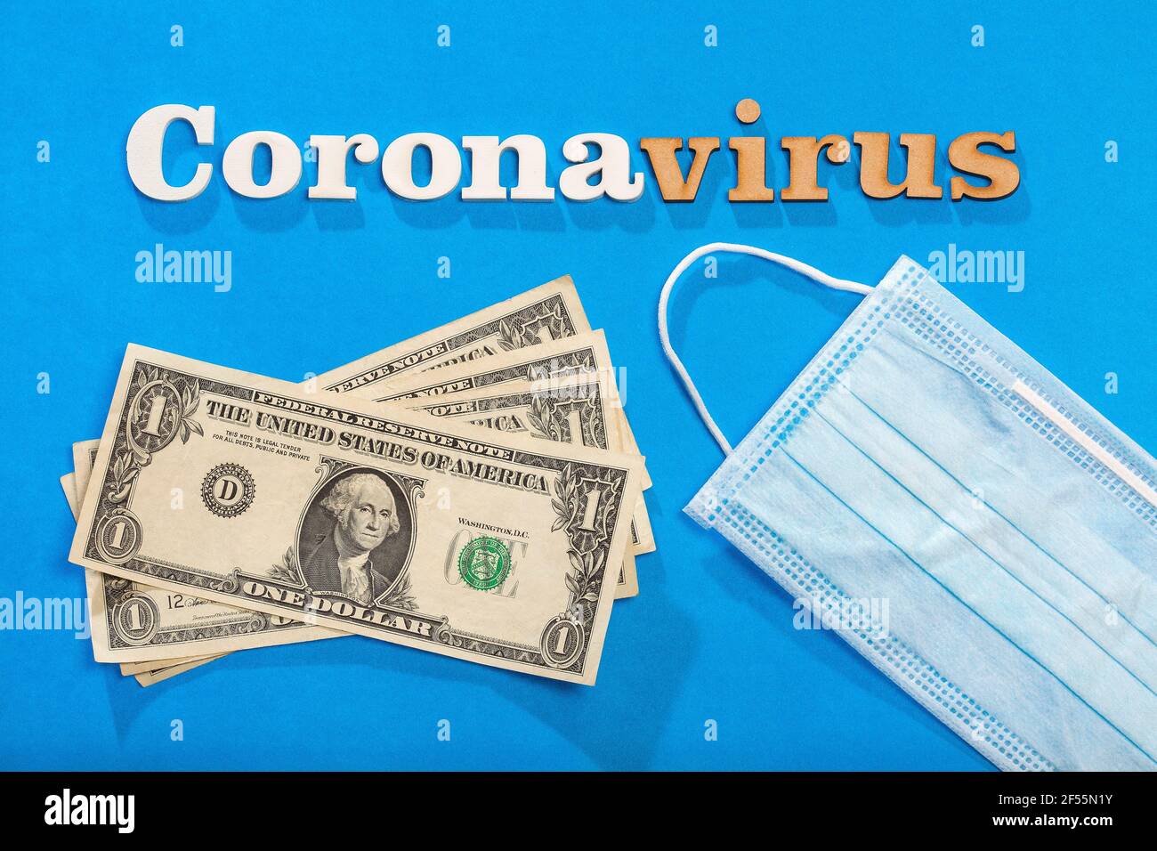 Testo della frase del coronavirus su sfondo blu con maschera protettiva e carta soldi Foto Stock