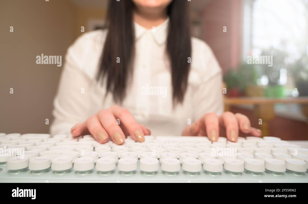 Primo piano donna che scrive su tastiera bianca. Lavorare dal concetto domestico. Foto Stock