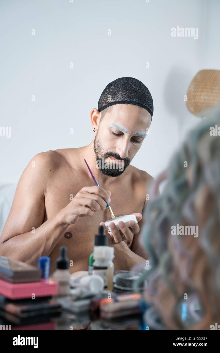 Uomo che indossa la rete per capelli tenendo spazzola con la polvere per il  viso a. casa Foto stock - Alamy