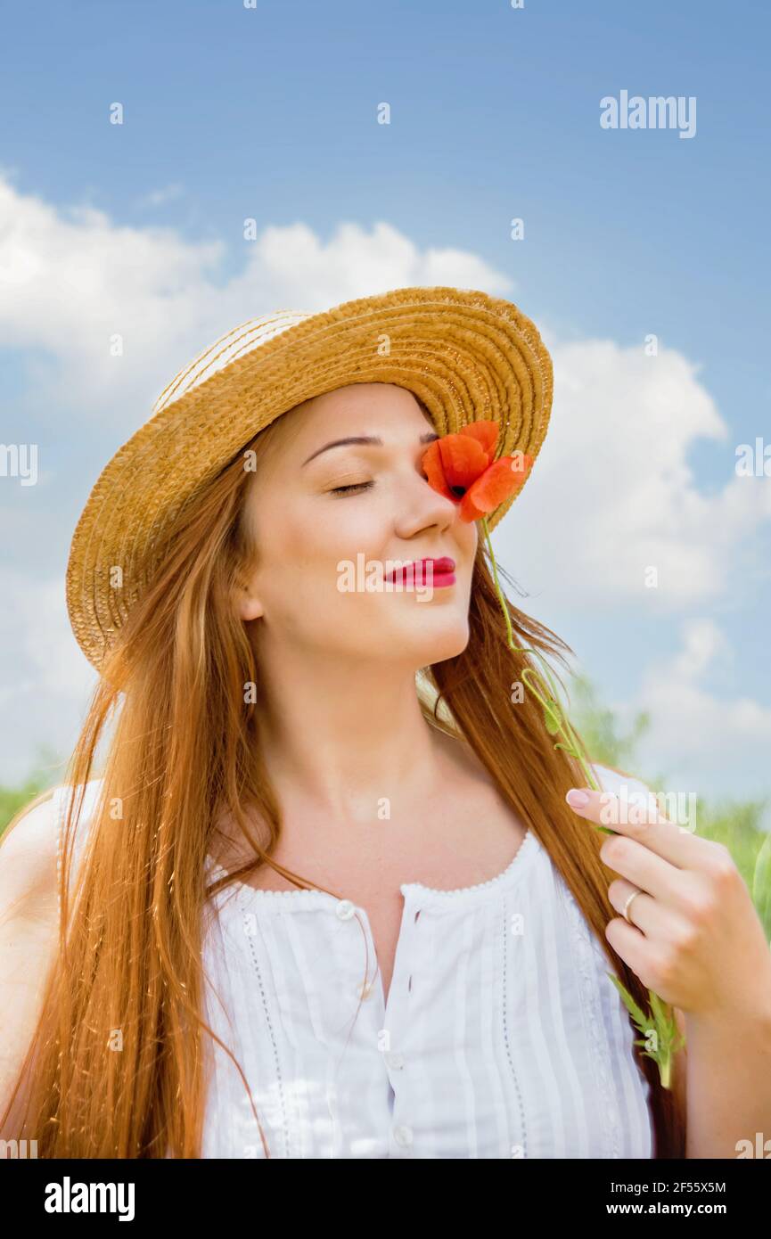 Ucraino bella donna in campo papaveri ritratto esterno. Raccolta papaveri e fiore di mais in campo estivo. Simbolo della memoria dei papaveri in fiore. Ukrain Foto Stock
