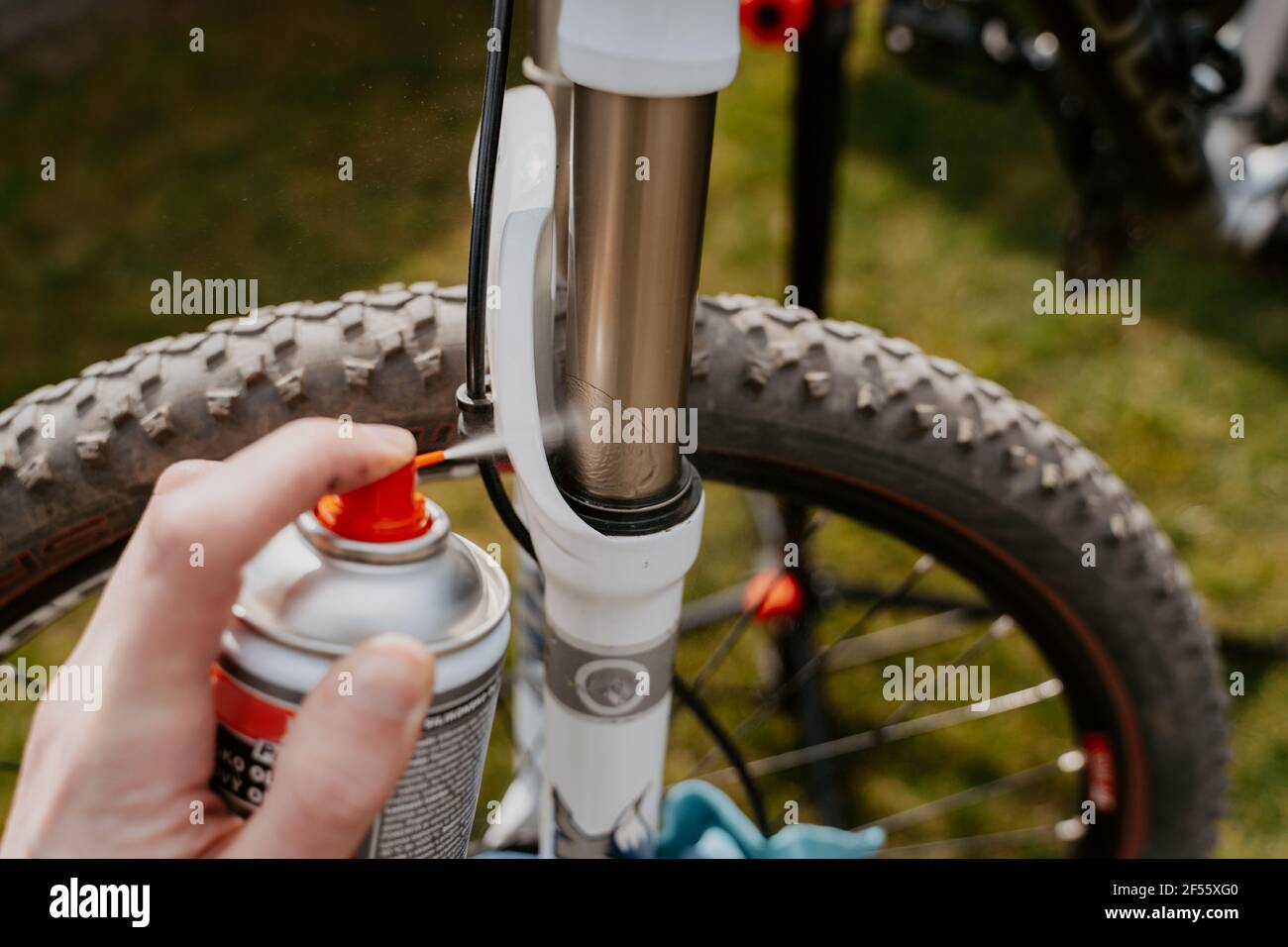 Vista ravvicinata della ruota e dello pneumatico della bicicletta, profondità ridotta. Spruzzare olio sulla forcella Foto Stock