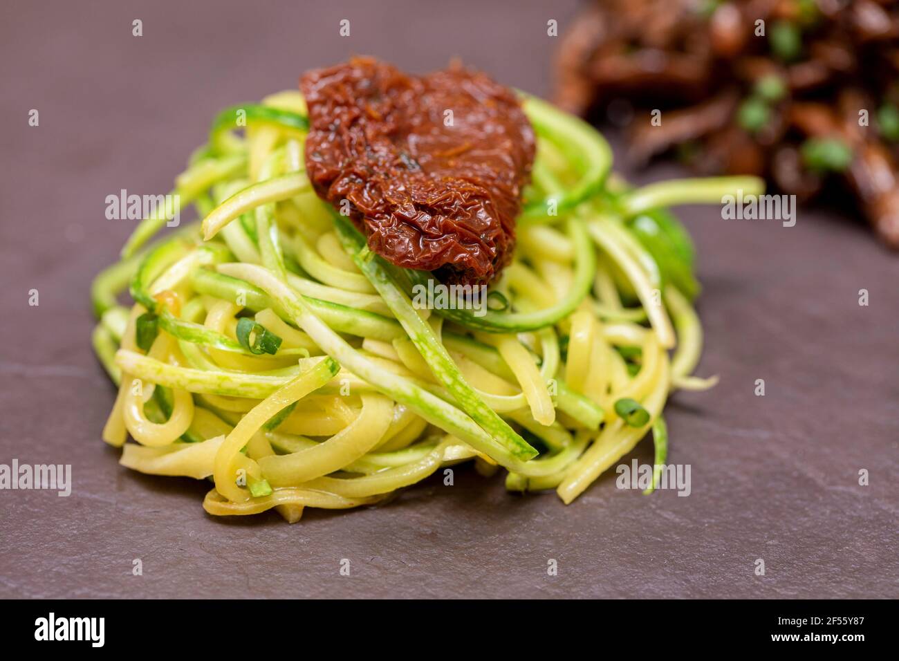 Spaghetti di zucchine con pomodori disidratati ed essiccati Foto Stock