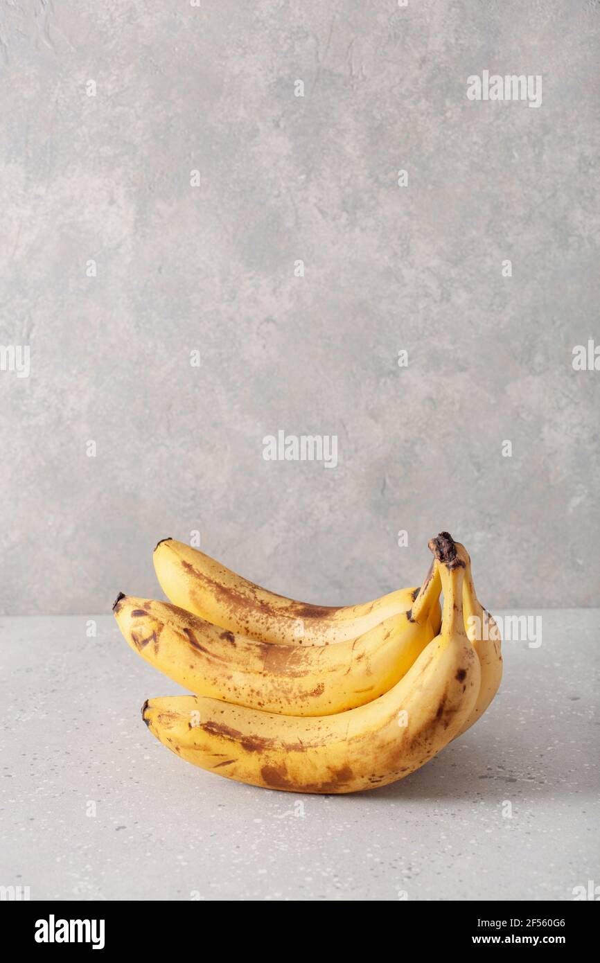 banane biologiche mature su fondo di cemento. concetto di cibo brutto zero rifiuti Foto Stock