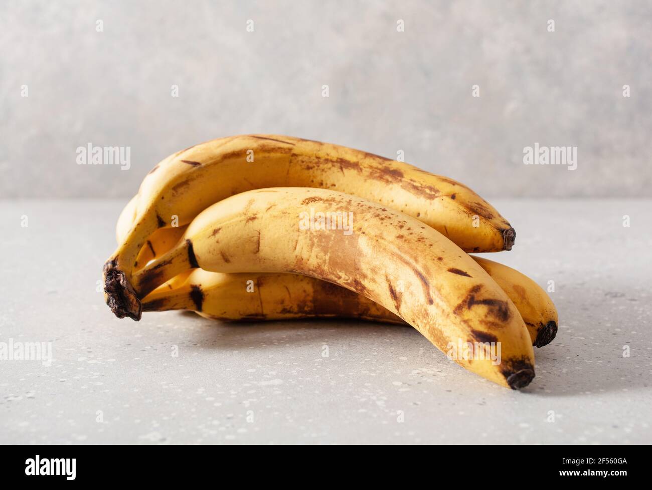 banane biologiche mature su fondo di cemento. concetto di cibo brutto zero rifiuti Foto Stock