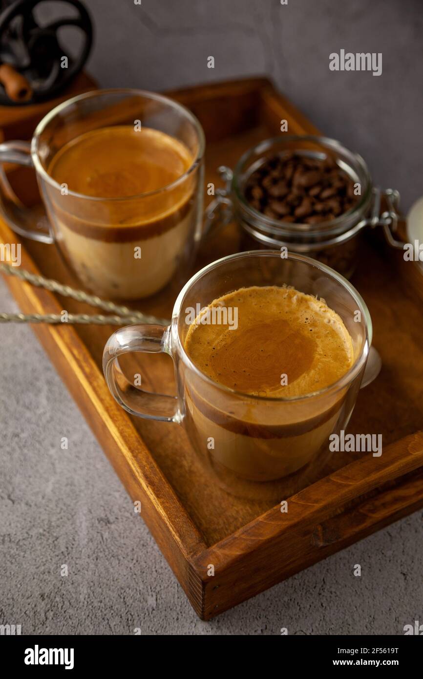 Dalgona Coffee - la bevanda coreana di caffè su sfondo di legno. Caffè istantaneo o espresso in polvere con zucchero e acqua calda. Algone montato ghiacciato Foto Stock