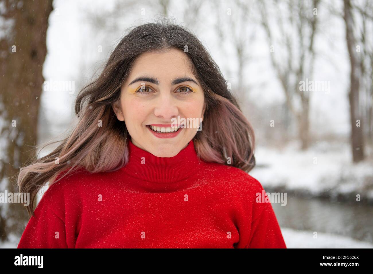Sorridente bella donna con l'ombra degli occhi durante l'inverno Foto Stock