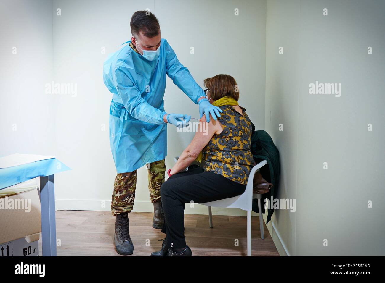 Un medico inocula una donna con il vaccino AstraZeneca COVID-19 hotspot presidiato da personale medico dell'esercito. Torino, Italia - Marzo 2021 Foto Stock