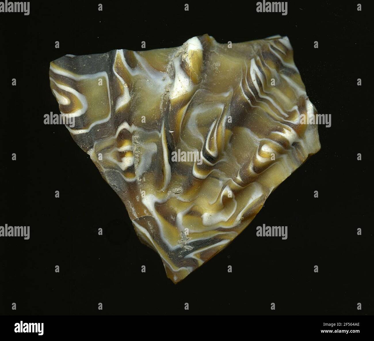 Frammento di uno shell di nervatura. La curvatura del frammento di vetro e le cinque nervature ottenute consentono l'assegnazione ad un guscio di nervatura. Il vetro marrone da scuro a chiaro è composto da pezzi di spirali bianche. Per la produzione, diversi vetri colorati sono stati stampati in tubi e aste. Questi sono stati compressi e riscaldati, causando una barra lunga. Il vetro affettato ​​now aveva differenti motivi amorfi o floreali. Successivamente, molte di queste piastrine sono state ripiegate insieme, riscaldate nuovamente e pressate nella forma vascolare. Burry per l'elaborato processo di fabbricazione e la sua fragilità è stato uno degli articoli di lusso di Foto Stock