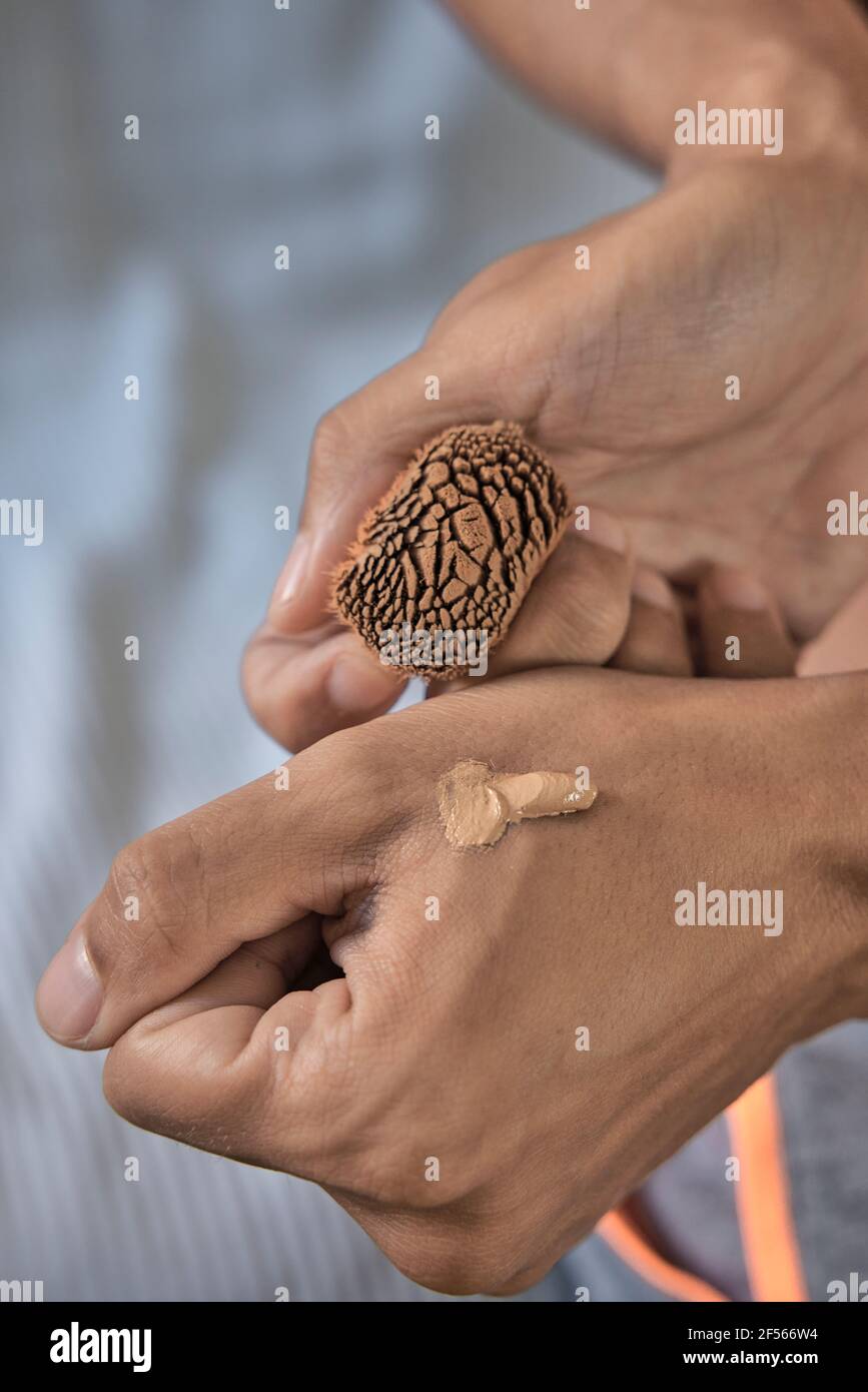 Adulto medio con fondazione liquida a portata di mano Foto Stock