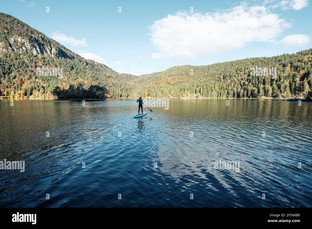 Germania, Baviera, Garmisch Partenkirchen, giovane donna levarsi in piedi sul lago Eibsee Foto Stock
