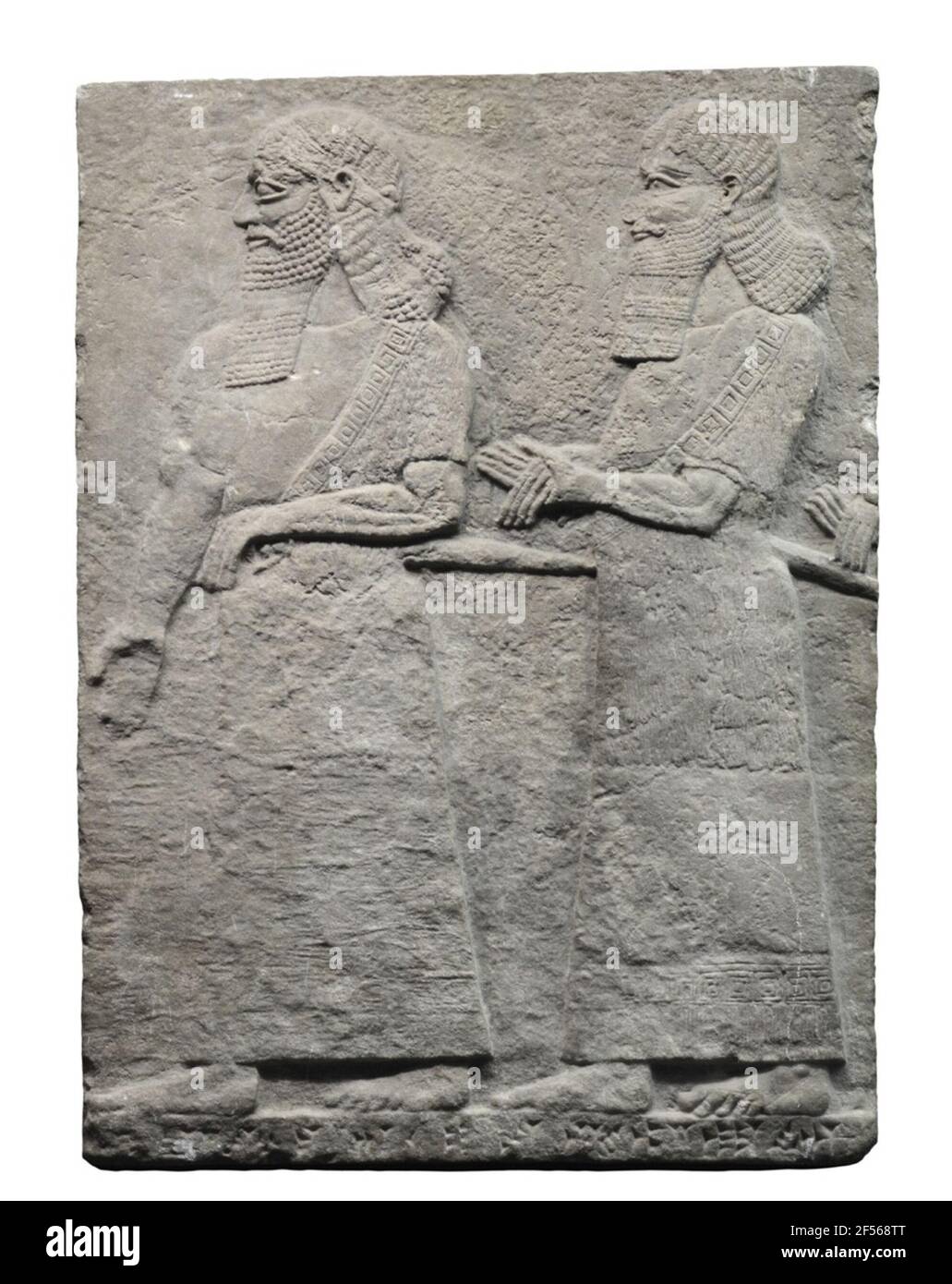 Muro di rilievo dal palazzo del Tiglathpile III .. Il rilievo mostra due bearded, con una spada figure maschili in un lungo accappatoio con pedaggio e porte meanderbord. Il primo sostiene la mano sulla sua spada, il secondo ha messo le mani interposte. Dietro di lei sono le mani ripiegate di un terzo uomo da vedere, che è stato tagliato durante il deserto del piatto originale. Sono mostrati ufficiali militari o civili del re. Si tratta di una sezione di una scena in cui i legami il re è arroccato o si trova in piedi, mentre il movimento di destra treno di funzionari gli fa messaggio o prigionieri presentati. Poiché la figura di sinistra porta un He Foto Stock