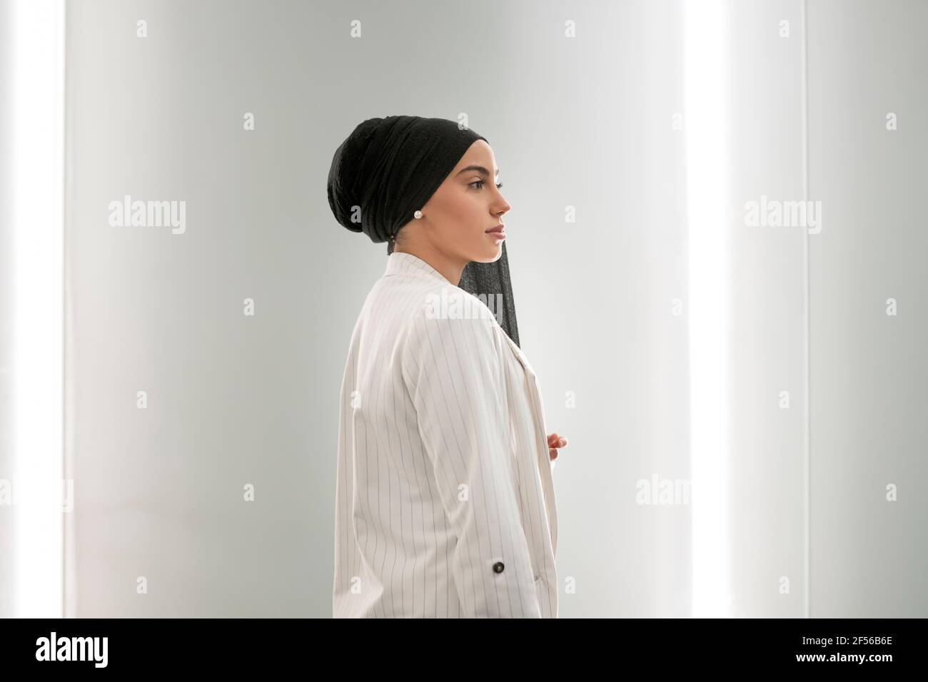 Contemplare una donna araba in piedi a muro nel centro commerciale Foto Stock