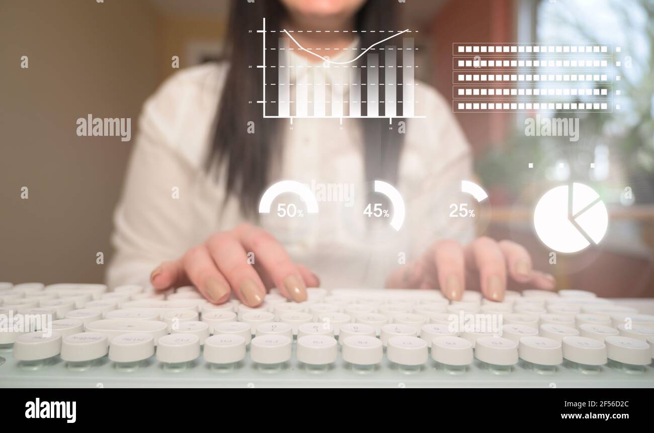 Primo piano uomo d'affari che scrive su una tastiera bianca, analizzando i grafici dei dati aziendali. Analisi mensile dei profitti aziendali, del business e della tecnologia Foto Stock
