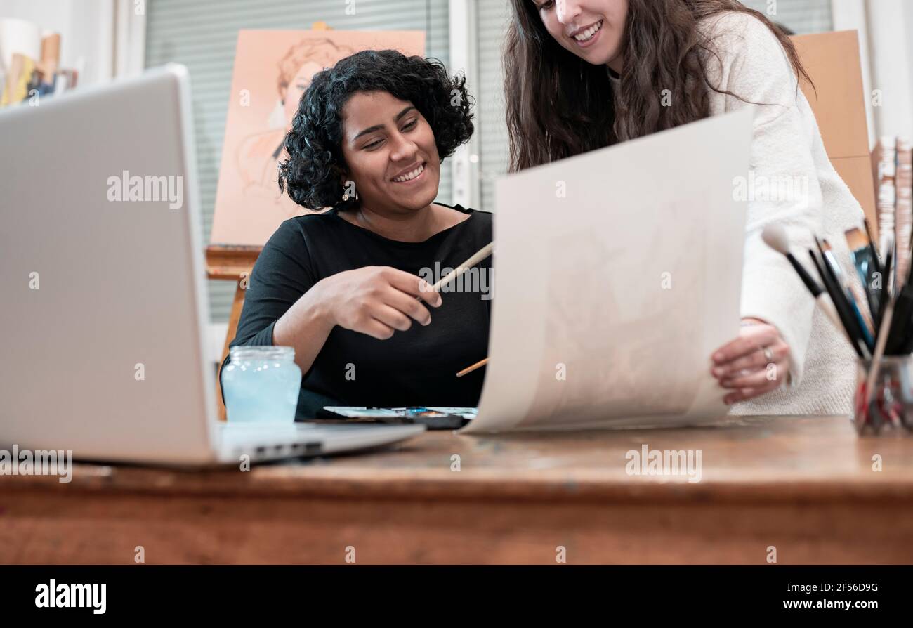 Pittori femminili che discutono sopra la pittura in studio Foto Stock