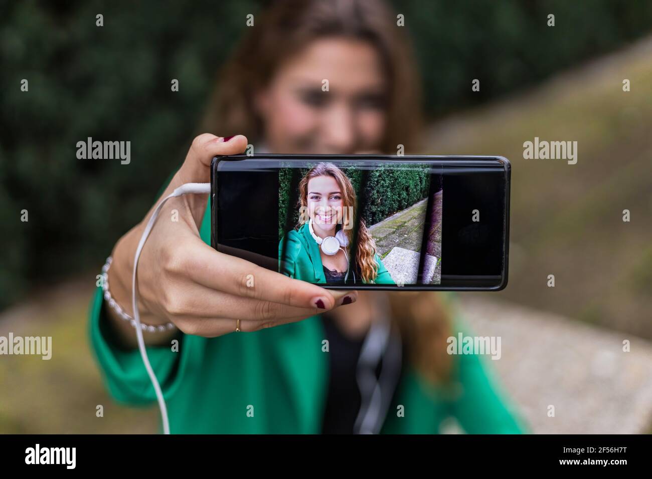Donna che mostra selfie prese su smartphone all'aperto Foto Stock
