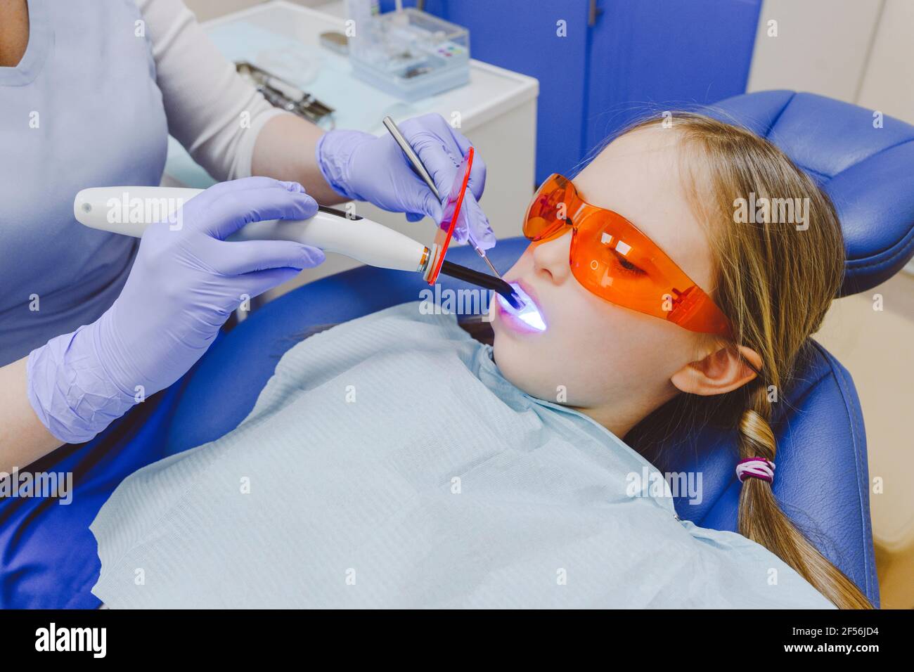 Bambina sdraiata in sedia dentista durante l'esame dentale Foto Stock