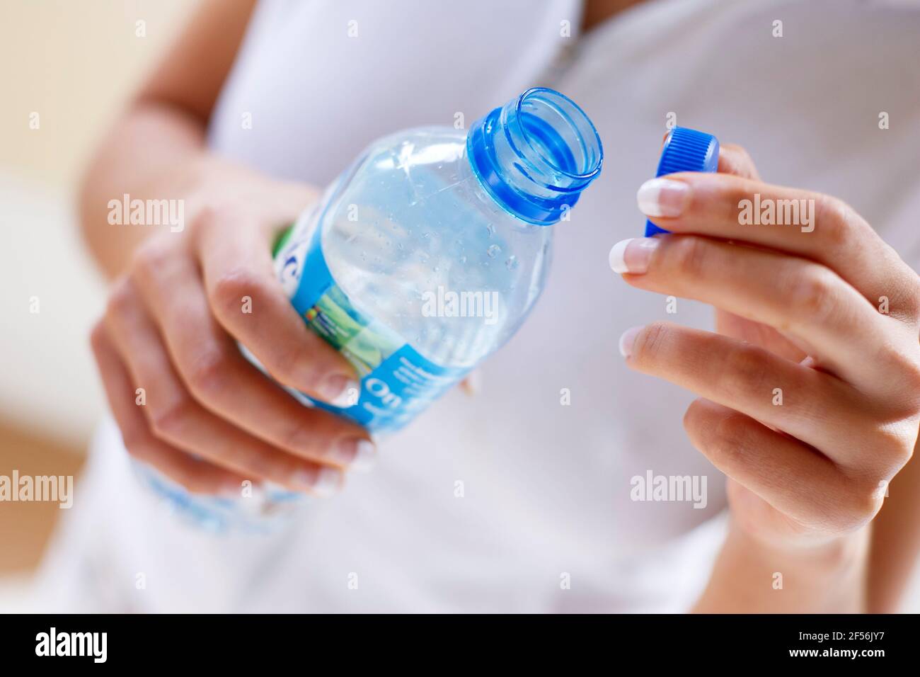 Donna che mantiene l'acqua in bottiglia Foto Stock