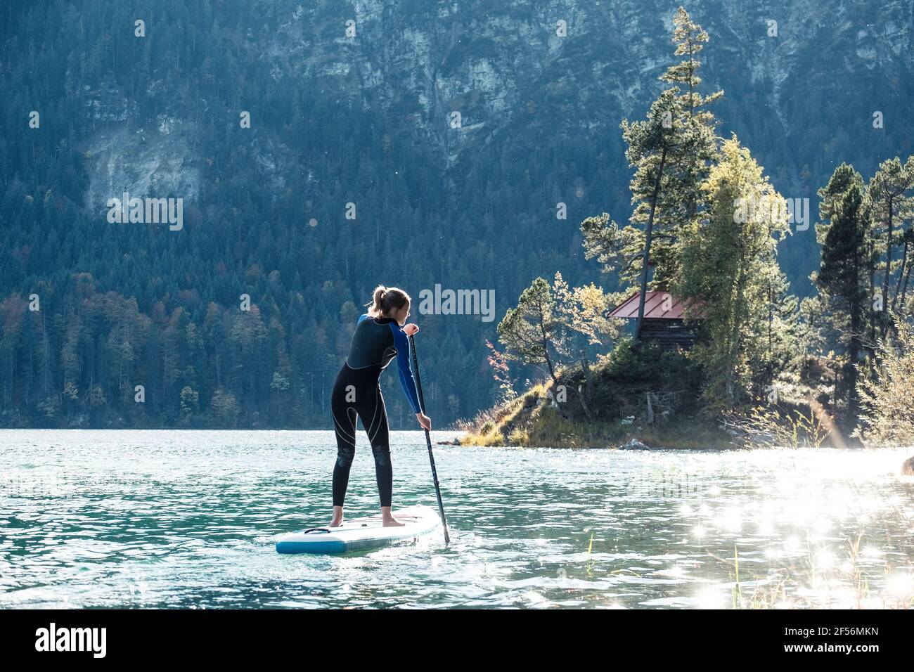 Germania, Baviera, Garmisch Partenkirchen, giovane donna levarsi in piedi sul lago Eibsee Foto Stock