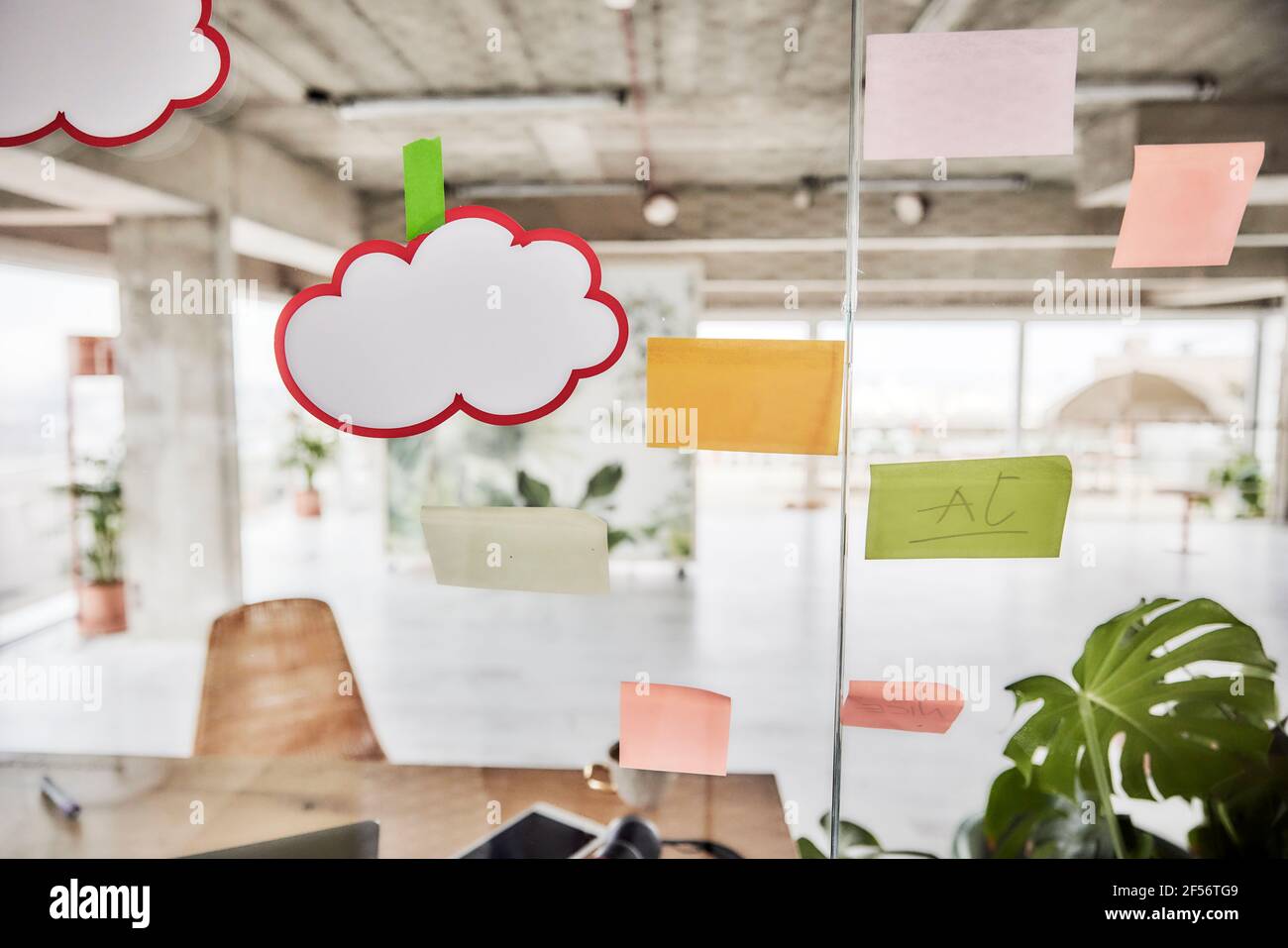 Note appiccicose sulla parete di vetro dell'appartamento vuoto Foto Stock