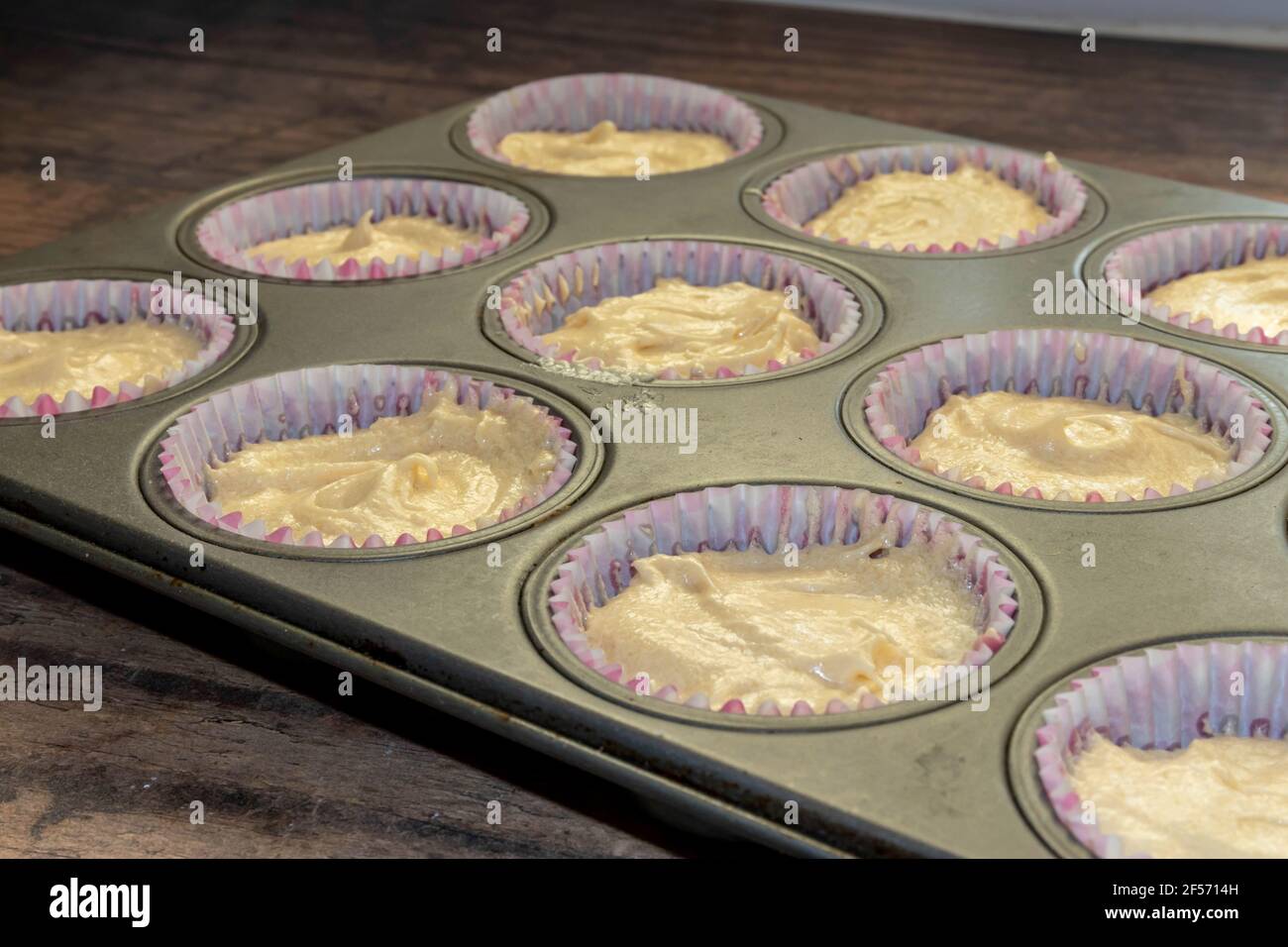 Casse per muffin con Batter in attesa di cottura Foto Stock