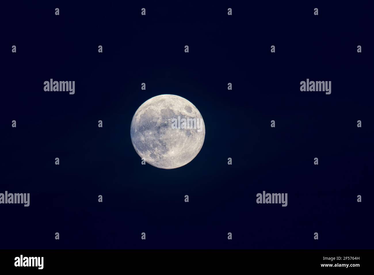 Una volta in una Luna Blu - UNA luna piena dentro un cielo blu scuro poco dopo il tramonto Foto Stock
