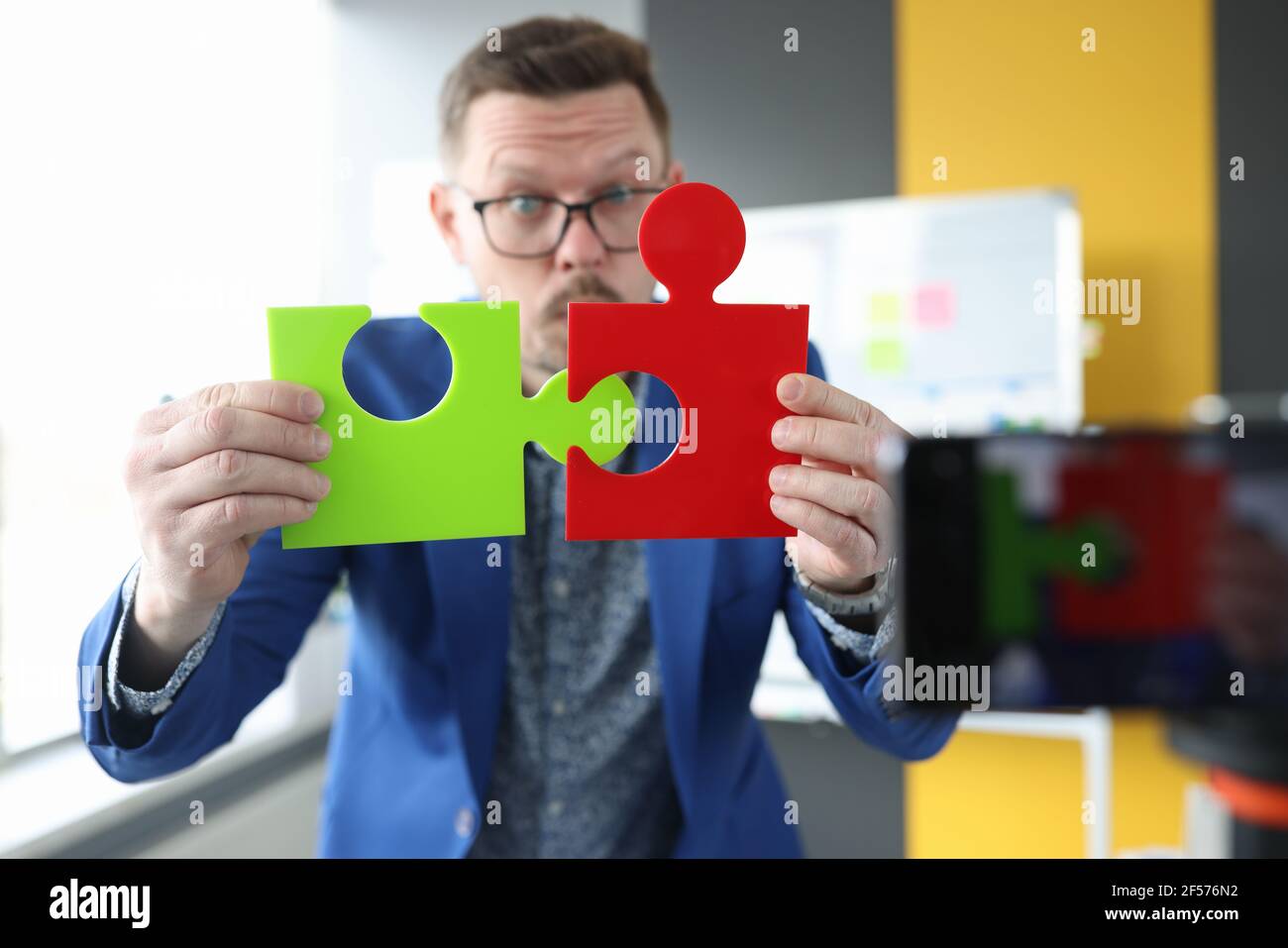 Blogger maschile business collega puzzle colorati closeup Foto Stock