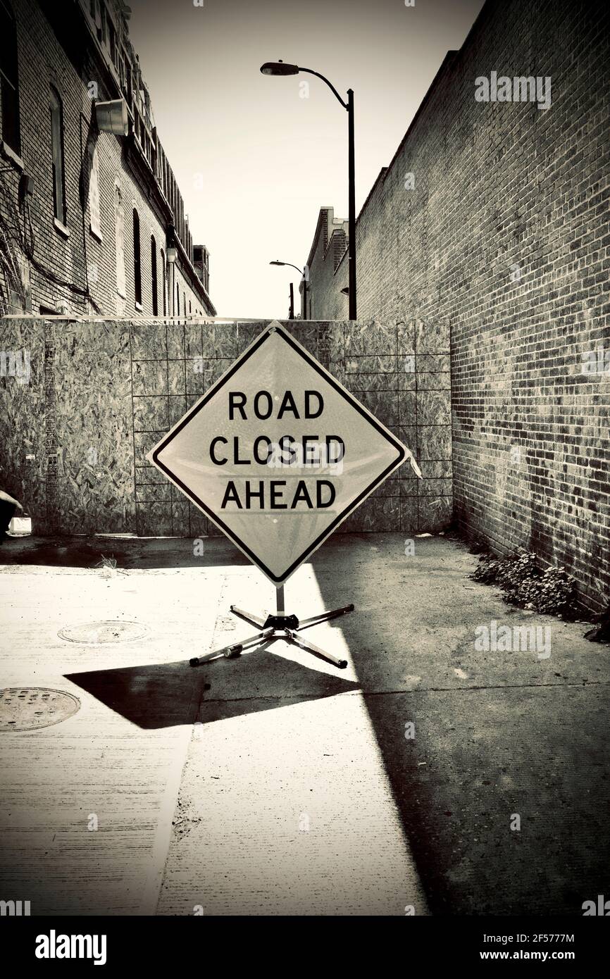 Segnale strada chiusa. Vicolo bloccato con edifici in mattoni su entrambi i lati. Foto Stock