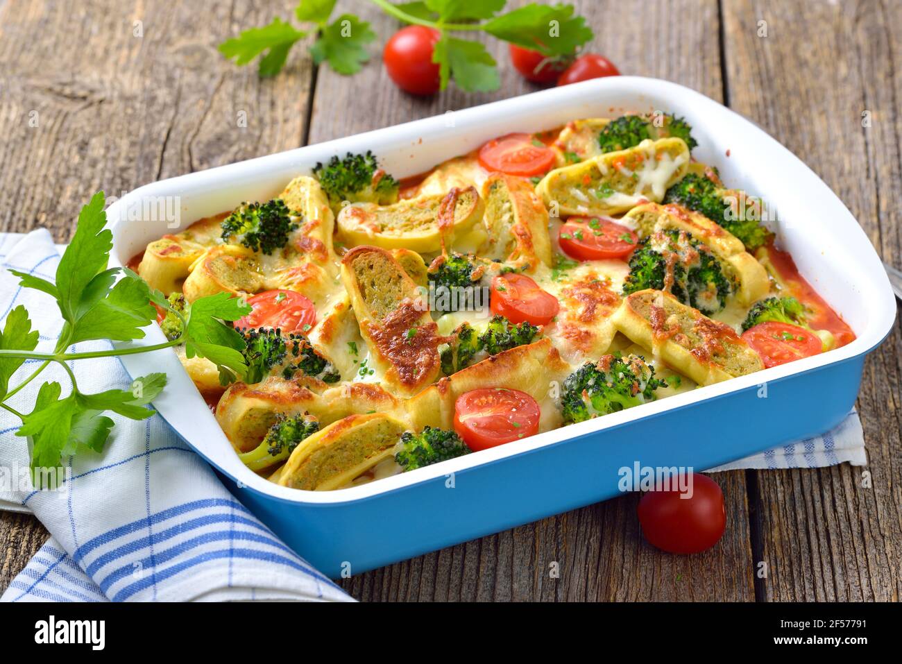 Casseruola vegetariana con ravioli vegetali svevi tagliati, pomodori, broccoli e formaggio serviti caldi dal forno Foto Stock