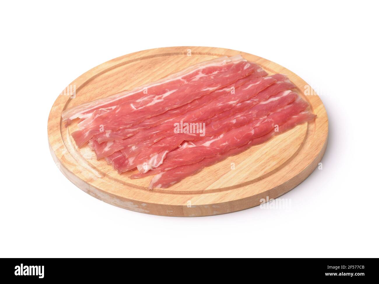 Strisce di pancetta su tagliere di legno isolate su bianco Foto Stock