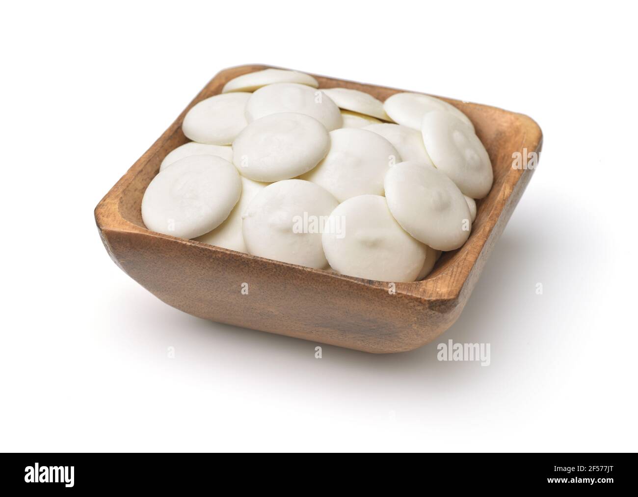 Ciotola di legno di bottoni di cioccolato bianco isolato su bianco Foto Stock