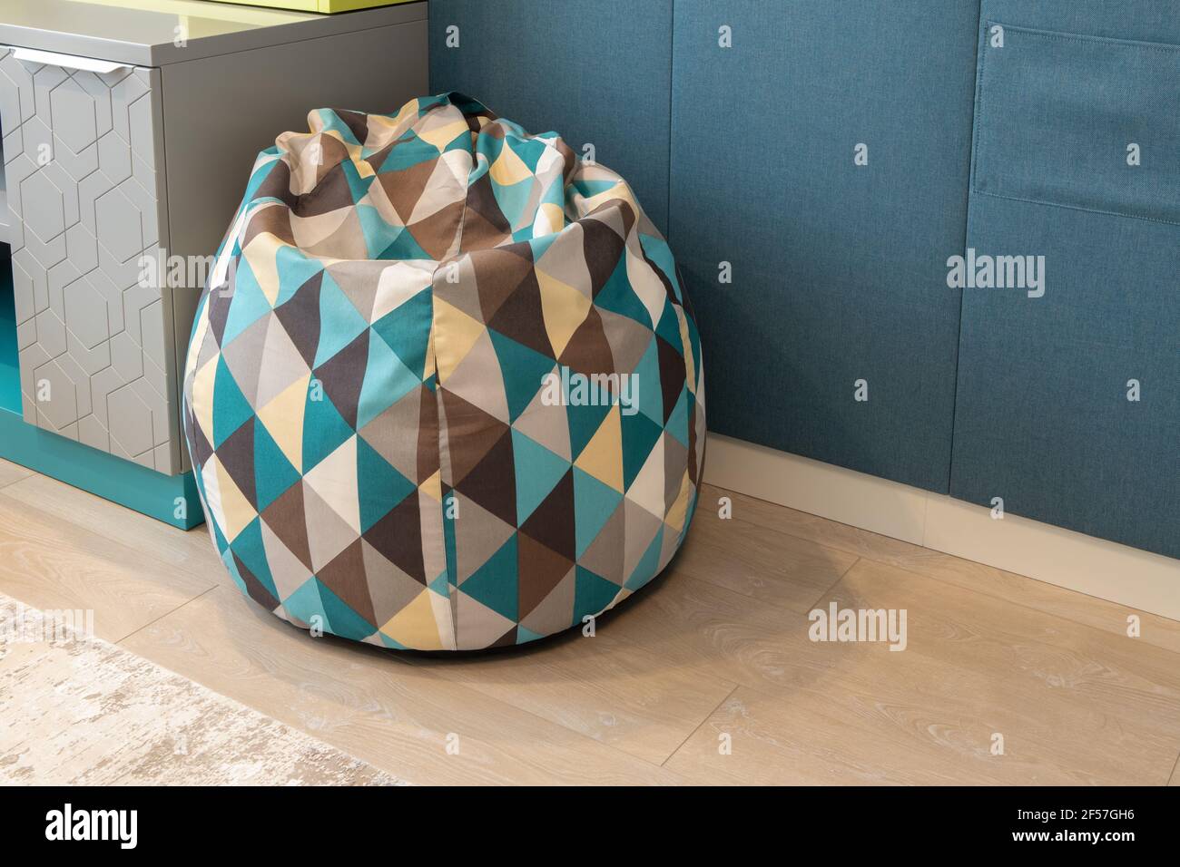 Borsa di fagioli o sedia a forma di pera imbottita, con motivi geometrici,  triangoli, nella stanza dei bambini. Toni neutri. Dettagli concettuali  della modalità Foto stock - Alamy