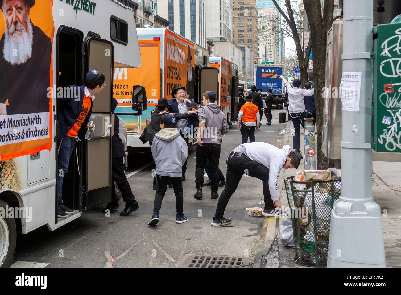 New York, Stati Uniti. 24 Marzo 2021. I membri della comunità di Lubavitcher prendono una pausa dalla loro Parata di passaggio dei carri armati Mitzvah a Chelsea a New York mercoledì 24 marzo 2021. La setta di Lubavitcher degli Hasidim, i adoratori ebrei ultra-ortodossi, continua a fare il loro sproach ai membri decaduti della fede ebraica. La Pasqua inizia la sera di sabato 27 marzo. (ÂPhoto di Richard B. Levine) Credit: Sipa USA/Alamy Live News Foto Stock