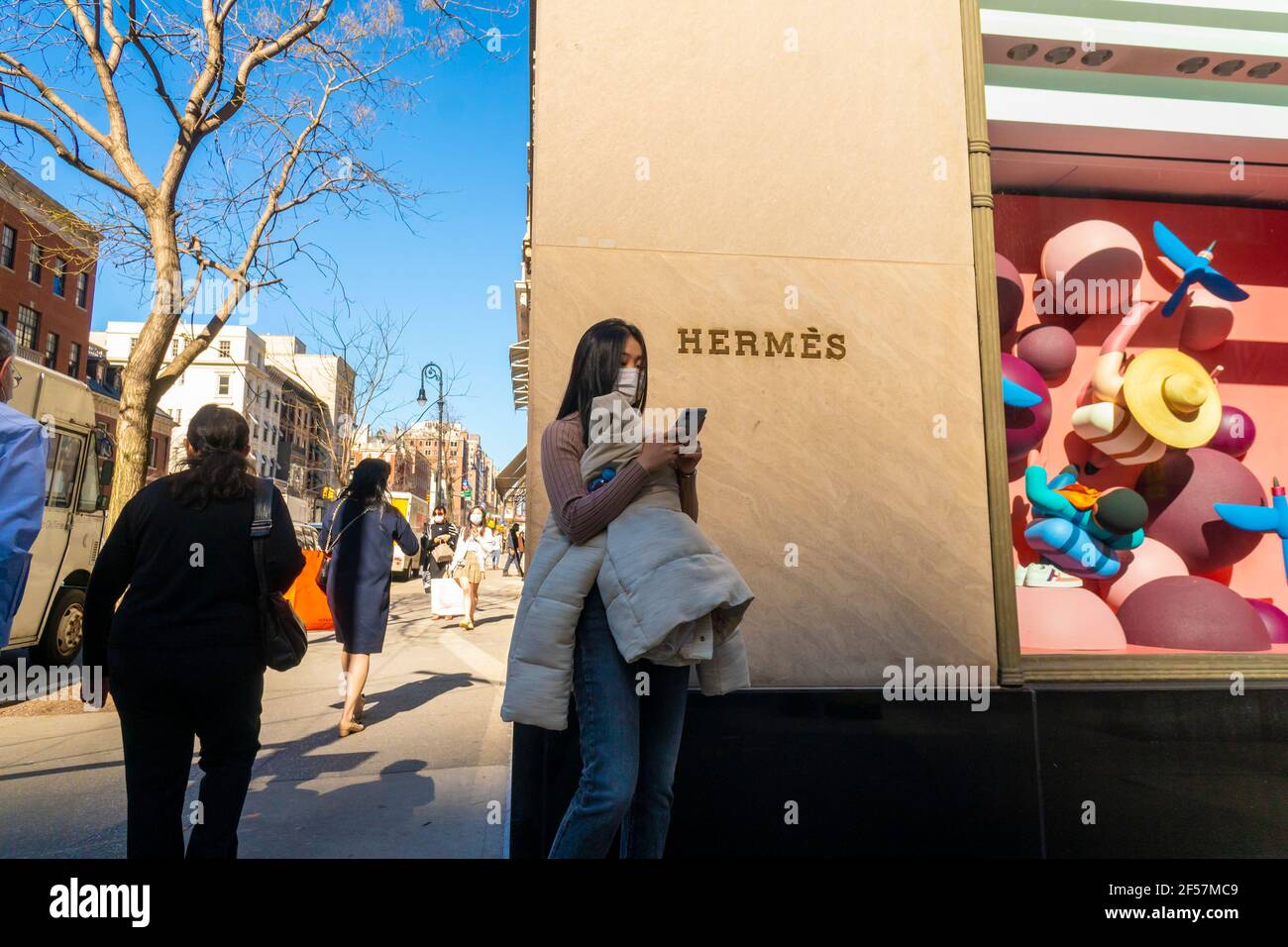 Lo shopping distratto attende di fronte al negozio Hermés su Madison Avenue a New York venerdì 12 marzo 2021. (© Richard B. Levine) Foto Stock