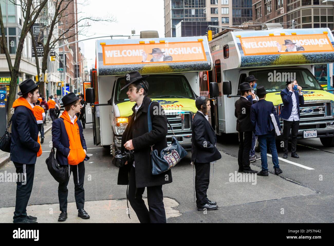 I membri della comunità di Lubavitcher prendono una pausa dalla loro Parata di passaggio dei carri armati Mitzvah a Chelsea a New York mercoledì 24 marzo 2021. La setta di Lubavitcher degli Hasidim, i adoratori ebrei ultra-ortodossi, continua a fare il loro sproach ai membri decaduti della fede ebraica. La Pasqua inizia la sera di sabato 27 marzo. (© Richard B. Levine) Foto Stock