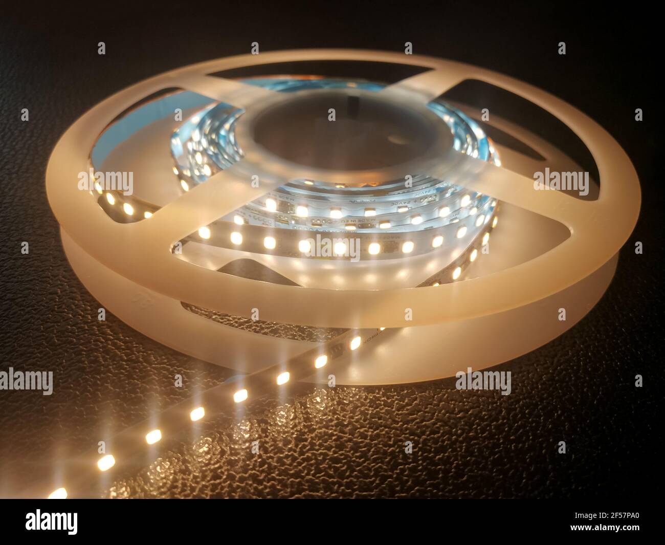Striscia LED a diodo a emissione luminosa flessibile per varie installazioni di illuminazione come luce d'atmosfera su sfondo scuro Foto Stock